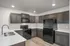 Modern kitchen with sleek black appliances, elegant wooden cabinets, and spacious countertops.