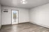Bright and spacious room featuring elegant hardwood flooring, large windowed door leading to a balcony, and modern baseboard heating.