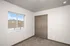 Bright and inviting bedroom featuring a large window with outdoor views and a spacious closet with wooden doors.