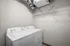 Modern laundry room with a sleek washer and dryer set, featuring ample wire shelving for convenient storage.