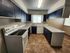 Charming kitchen with sleek navy cabinets, modern appliances, and ample counter space, offering a stylish and functional cooking area.