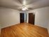 Spacious room with hardwood flooring, ceiling fan, and double closets ideal for versatile use.