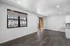 Modern apartment living room with open floor plan, large windows, and balcony access, offering ample natural light and elegant flooring.