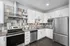 Modern kitchen with sleek stainless steel appliances, chic tile backsplash, and ample white cabinetry.