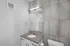 Modern bathroom with sleek gray tiles, stylish vanity, and bright lighting creating a fresh ambiance.