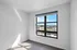 Bright and airy room with a large window offering impressive cityscape views and abundant natural light.