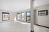 Bright and spacious living area with large windows and modern flooring, complete with an air conditioning unit for comfort.