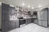 Modern kitchen with dark cabinetry, stainless steel appliances, and stylish tile backsplash offering sleek and functional design.