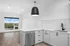 Modern kitchen with sleek stainless steel appliances, spacious white countertops, and a large window with scenic views.