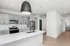 Modern kitchen with sleek gray cabinets, stainless steel appliances, and a spacious island with a stylish black pendant light.
