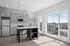 Modern kitchen with sleek cabinetry, central island, and large windows offering stunning city views.