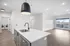 Bright, open-concept apartment with sleek kitchen island, modern pendant light, and in-unit laundry room.