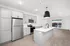 Modern open-concept kitchen with sleek gray cabinets, stainless steel appliances, and a stylish island overlooking a bright living area with large windows.