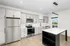 Modern kitchen with sleek gray cabinets, stainless steel appliances, and a spacious island under stylish lighting.
