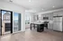 Modern open-concept kitchen with sleek gray cabinets, stainless steel appliances, and wood flooring, featuring a picturesque window view of a clock tower.