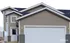 Charming two-story home with modern siding and a spacious white garage, perfect for a warm and welcoming family residence.
