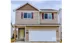 Charming two-story home with a spacious garage, featuring a welcoming entrance and stylish exterior with brick and siding accents.