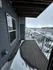 Charming apartment balcony with a wooden deck, offering a cozy outdoor space and a wintery view of the surroundings.