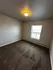 Cozy and bright carpeted room with natural light from a large window, perfect for a bedroom or home office.