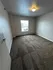 Bright and inviting bedroom with fresh carpet and natural light from a large window.