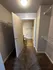 Inviting apartment interior featuring a cozy carpeted hallway leading to a modern bathroom with tiled flooring.