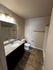 Elegant bathroom with a modern granite countertop, sleek vanity mirror, and polished tile flooring.