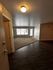 Inviting apartment entrance showcasing a blend of elegant hardwood and cozy carpet with abundant natural light.