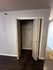 Contemporary closet space with open double doors, featuring sleek design and hardwood floors.