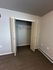 Spacious closet with double doors and plush carpet in a modern apartment.
