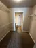 Spacious walk-in closet with carpet flooring and shelving, leading into a modern bathroom with tile flooring.