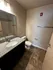 Modern bathroom with elegant granite countertop, sleek fixtures, and tiled flooring offering a stylish and comfortable experience.
