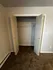 Spacious closet with double doors and ample shelving space in a cozy carpeted room.