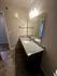 Contemporary bathroom with elegant granite countertop, large mirror, and stylish lighting.