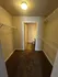 Spacious walk-in closet with plush carpet, ample shelving, and adjoining bathroom entrance.