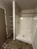 Modern bathroom with a sleek shower, built-in shelving, and stylish tiled flooring.