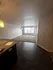 Inviting apartment interior with open-concept design, featuring a well-lit living area and elegant dark wood flooring.