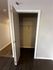 Spacious closet with a modern door and sleek wooden flooring, perfect for ample storage.
