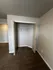 Spacious closet with open double doors in a modern carpeted room, showcasing ample storage space.
