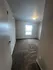 Bright, spacious carpeted room with natural light filtering through a window, perfect for relaxation or creative use.