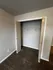 Spacious empty closet with bi-fold doors and plush carpet in a modern apartment.