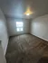 Bright and inviting bedroom with plush carpeting and ample natural light through a large window.