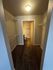 Spacious walk-in closet with ample shelving and cozy carpet leading to an ensuite bathroom.