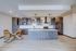 Modern kitchen with elegant wood cabinetry, large island, stainless steel appliances, and stylish dining area.