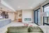 Contemporary living area with elegant open kitchen, featuring hardwood floors, modern lighting, and large windows for abundant natural light.