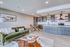 Modern open-concept living room featuring an elegant kitchen with wooden cabinets, stylish seating area, and chic decor accents.