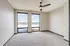 Bright and spacious room with modern ceiling fan and large windows offering scenic views.