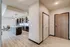 Modern entryway leading to an open-concept kitchen with chic pendant lighting and elegant cabinetry; ideal for stylish living.