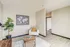 Modern living space with elegant decor featuring a comfortable armchair, stylish coffee table, and wall art of a world map, complemented by a lush indoor plant.