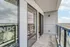 Modern apartment balcony with sleek glass railing offering expansive views of the surrounding landscape.