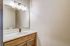 Chic and modern bathroom with a sleek vanity, elegantly lit mirror, and tasteful use of natural wood tones.